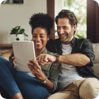 A couple use a tablet to browse for insurance online. 